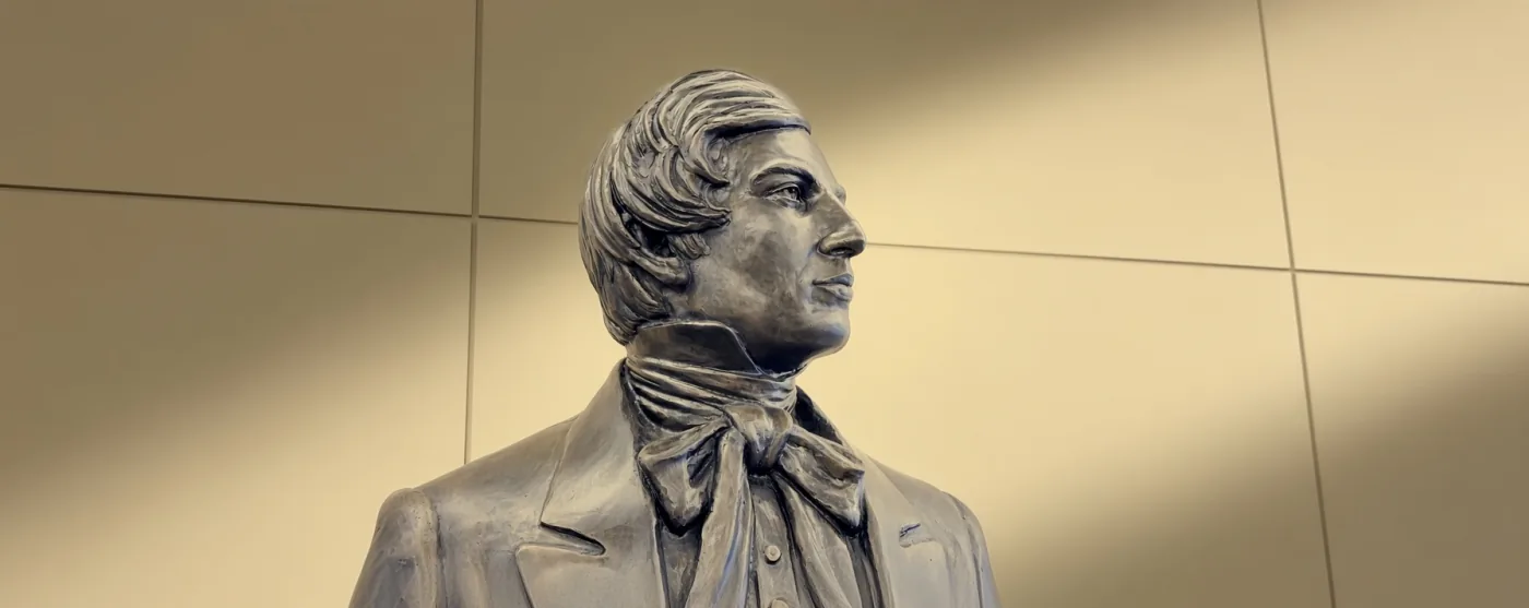 A bronze statue of Joseph Smith in profile, wearing a period coat and cravat.